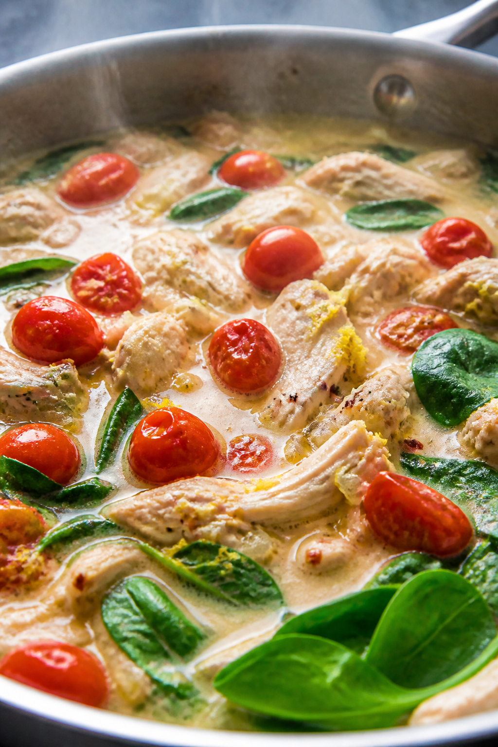 Cooking process — creamy lemon-garlic chicken skillet: Close-up of a sauté pan mid-cook with glos