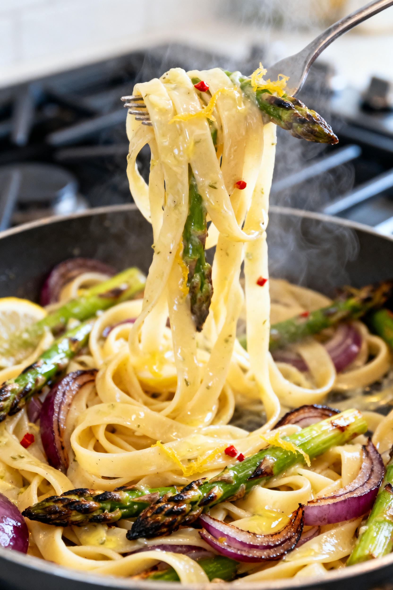 Close-up detail shot: Silky lemon-garlic pasta being tossed in a skillet, with glossy emulsified sau