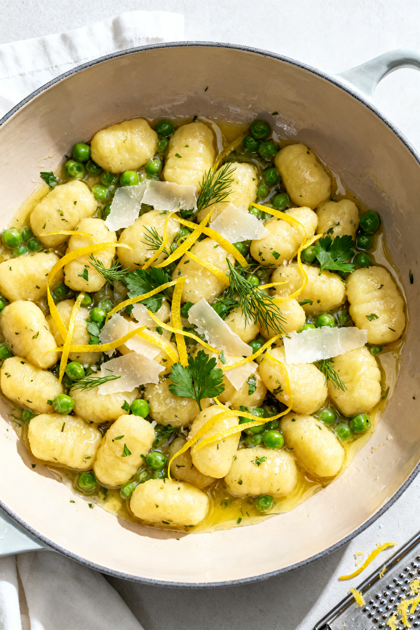 Tasty top view: Overhead shot of pillowy potato gnocchi just tossed in lemon-herb butter with peas a