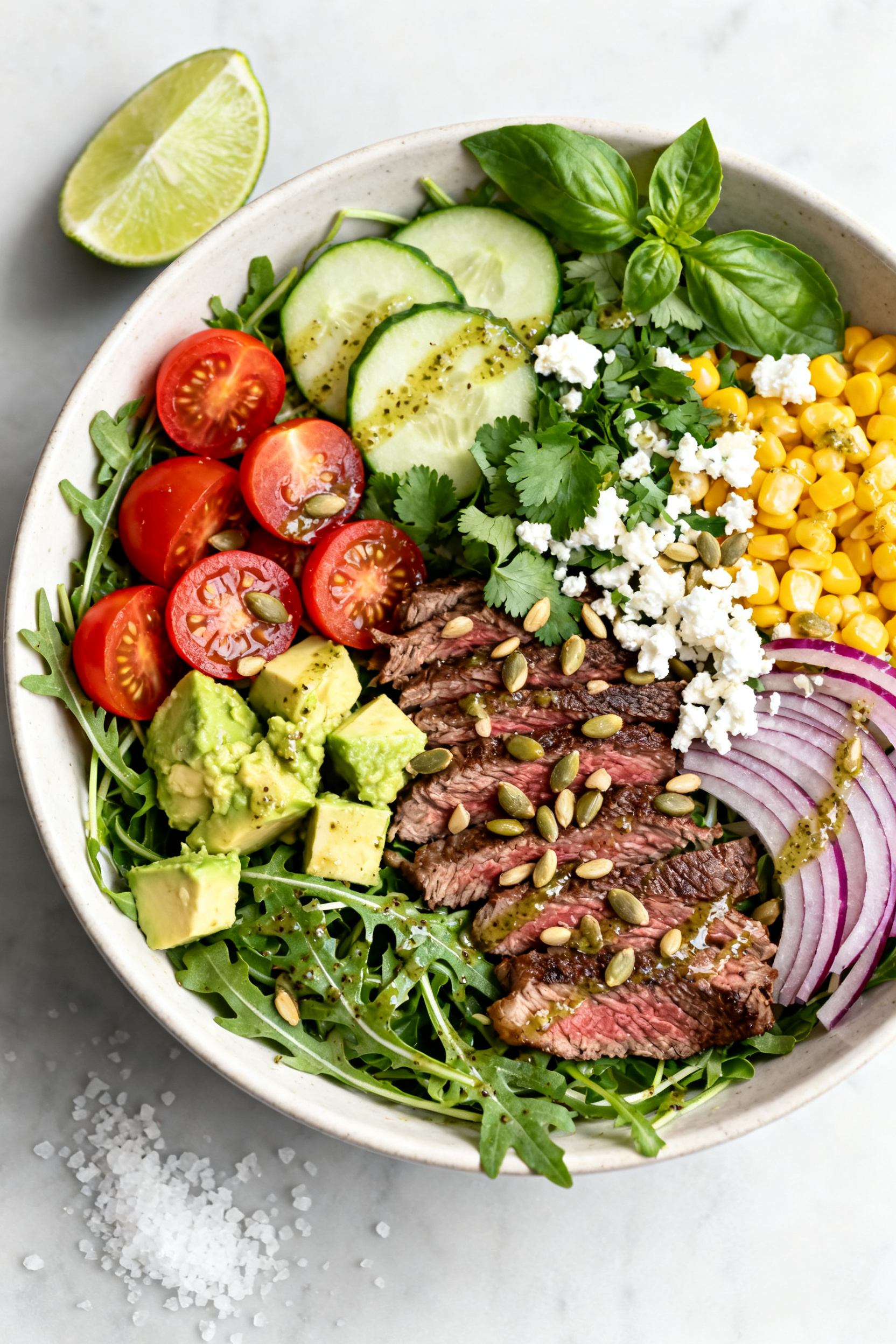 Tasty top view — Summer steak salad bowl: Overhead shot of a large shallow bowl layered with arugu