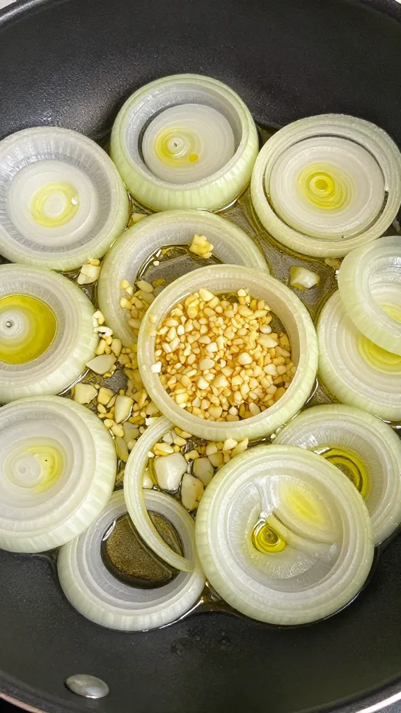 sliced onion and minced garlic sautéing in olive oil skillet