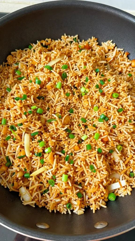 Golden fried rice with scallions in pan top-down